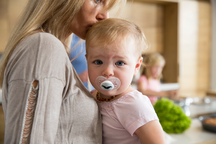 548555815 Portrait of female toddler in mothers arms in kitchen